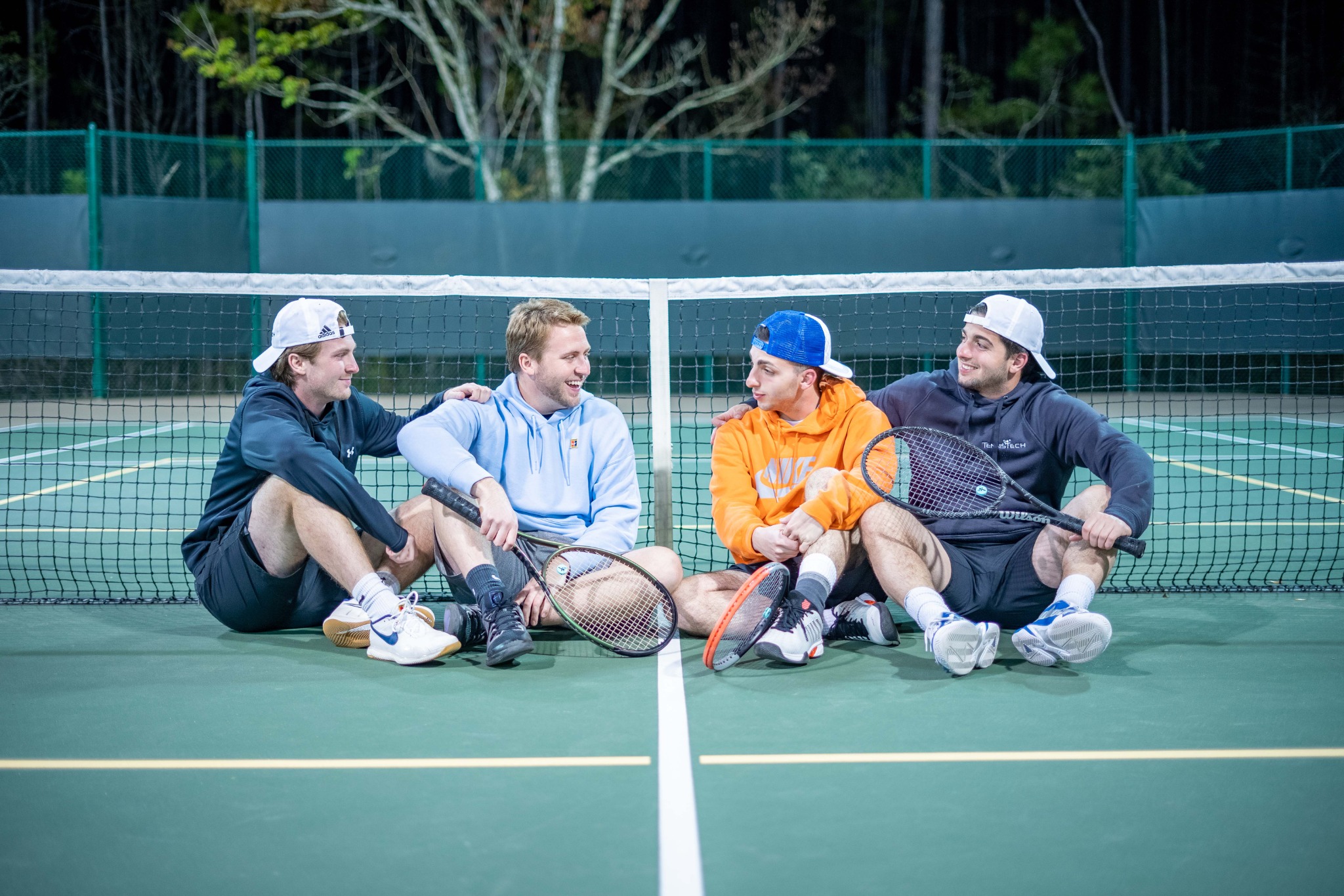 TennisTech coaches sitting on a tennis court